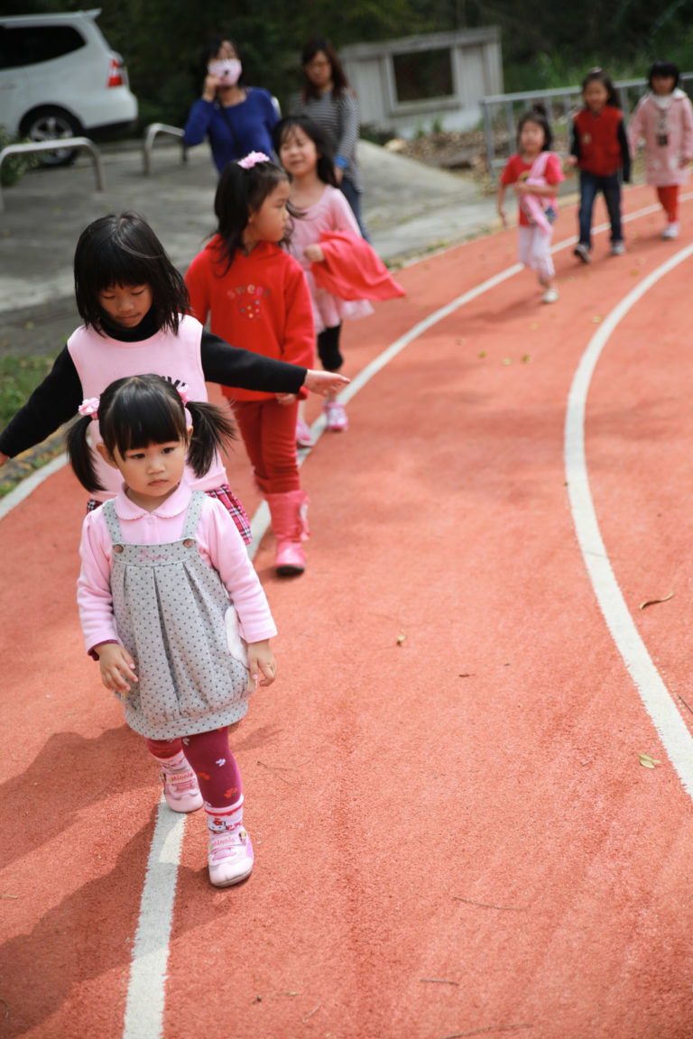 從操場回教室的路上，她莫名奇妙地變成了排頭，小朋友們排成一長條，順著跑道上的白線一路走回教室。